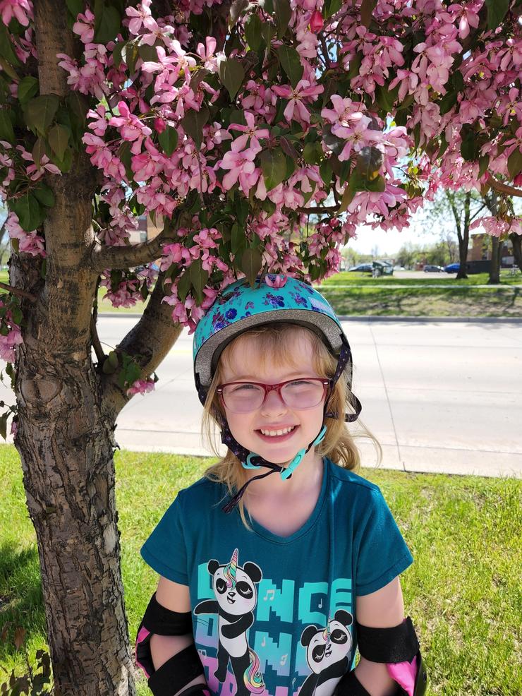 Lemonade stand owner, Lila, standing under a tree in Grand Forks